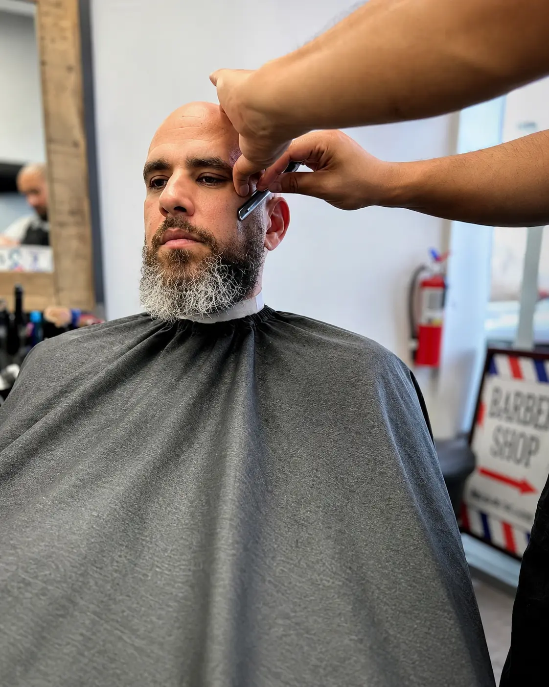Straight-razor detailing along the temple during a beard and outline service