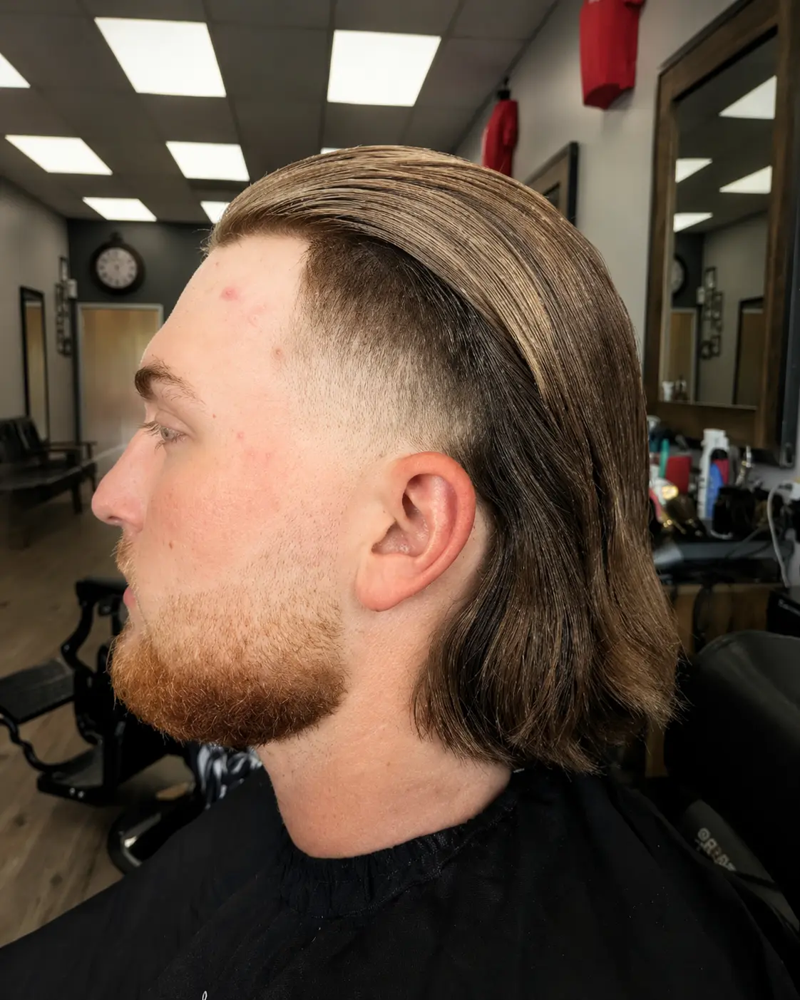 Slicked-back longer style with a disconnected taper and full beard shape-up