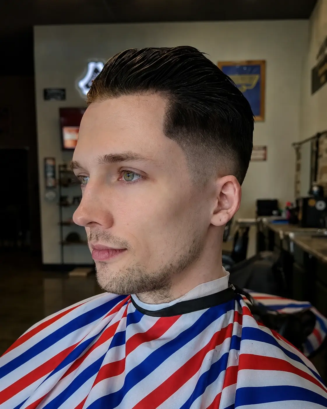Classic side-part taper with a razor-defined part and blended low fade